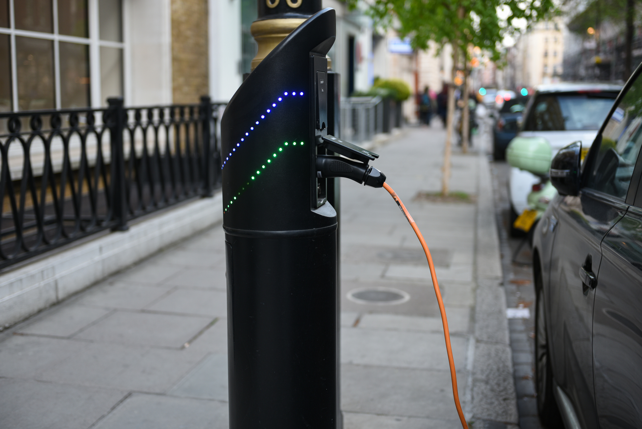 Photo of a parked car hooked up to an EV charging point