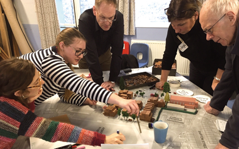 Duncombe Barracks design workshop A group of people gathered round a model of houses