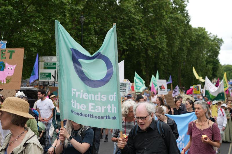 A group of people at a demo with Friends of the Earth banners