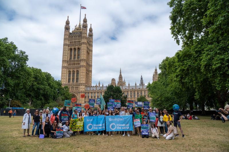 A large group of people outside of Westminster coming together for a photo to demand climate action