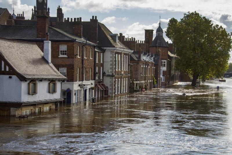 A row of buildings along a flooded street, with water almost up to the first floors