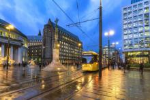 A city centre with a yellow tram