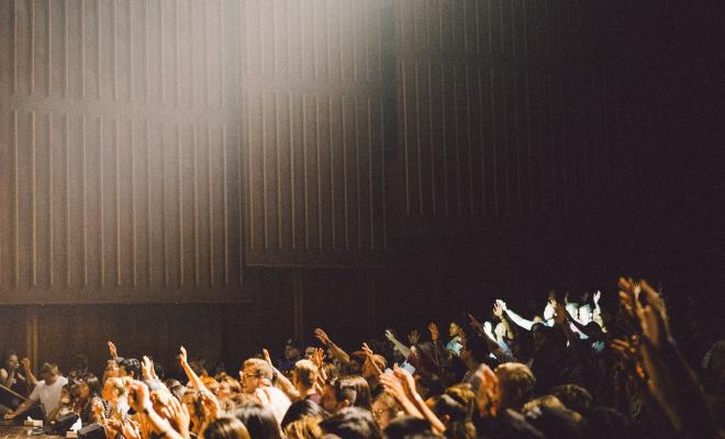 Raised hands in a big indoor meeting