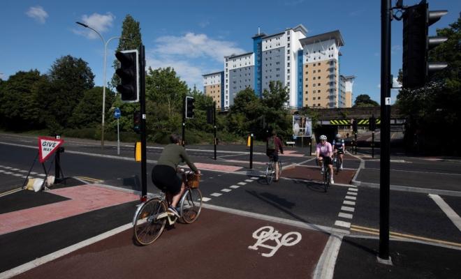 Roads with priority cycle lanes and happy cyclists in sunshine
