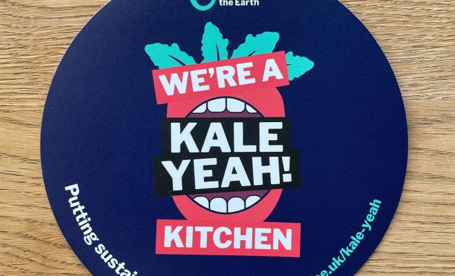 Circular window sticker that says "We're a Kale Yeah! Kitchen"