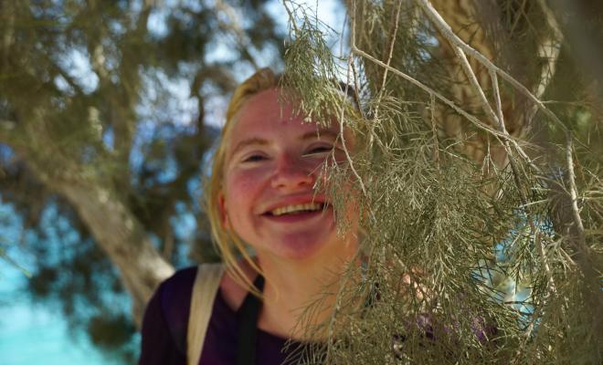 A smiley woman amongst trees 