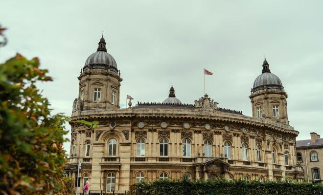 An elaborate stone building with towers and flags