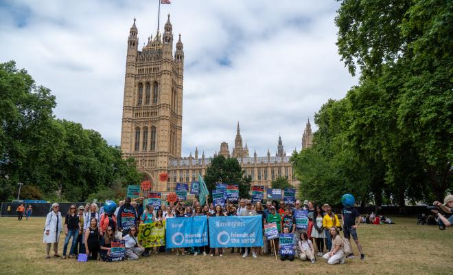 A large group of people outside of Westminster coming together for a photo to demand climate action