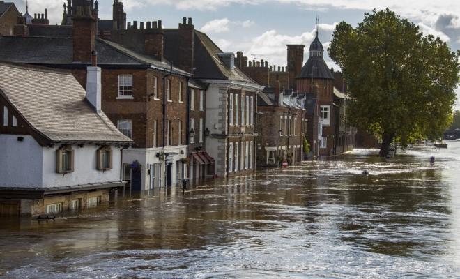 A row of buildings along a flooded street, with water almost up to the first floors